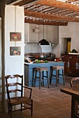 Small, blue-painted breakfast bar in rustic kitchen of Provençal country house