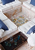 Ornamental floor mosaic in footwell of stone-flagged, sunken seating area