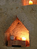 Spitz zulaufende Nische mit Kerzen in historischem Sandsteingemäuer