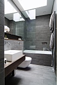Designerbad mit grauen Wand- und Bodenfliesen