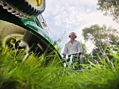 Man mowing lawn wearing ear protectors