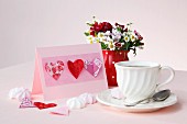 Pink invitation card decorated with paper hearts