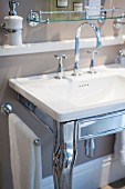 Elegant, shiny silver washstand with sink and curved tap fitting