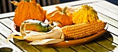 Autumn arrangement of corncobs and ornamental gourds