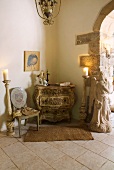 Baroque chest of drawers and chair next to candelabras on floor in corner of room in Mediterranean country house