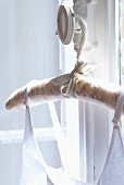 Fabric-covered coathanger hanging from window handle in Château Maignaut (Pyrenees, France)
