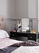 Dressing table next to bed in bedroom