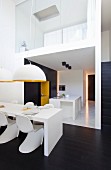Minimalist, open-plan interior in black and white with yellow accents
