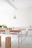 Pale dining table, tree stump stools and garden chairs