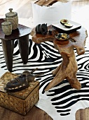 Geschnitzte Holztischchen mit afrikanischer Deko auf Zebrafell