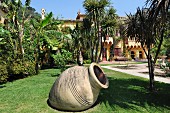 Extensive Mediterranean gardens; large amphora lying at an angle in foreground