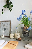 Diary, apothecary's bottles and grape hyacinths on small table