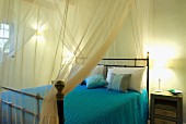 Transparenter Stoffhimmel über Doppelbett mit Vintage Metallgestell in mediterranem Schlafzimmer