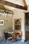 Gedeckter Frühstückstisch in Esszimmerecke unter rustikaler Holzkonstruktion an der Decke