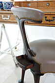 Detail of upholstered chair with decorative studs and leather cover