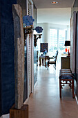 Modern stone sculpture in corridor and open doorway showing view of period furniture in modern living room