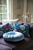 Floral scatter cushions on purple sofa
