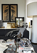 Living room with art objects and black couch, accents in gold