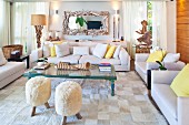 Fur-covered stools, driftwood artworks and huge seashells decorating inviting seating area with set of sofas