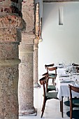 Set table in arcade with heavy stone columns in courtyard