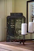 Antique lantern covered with printed photo motif and white pillar candles on candlesticks