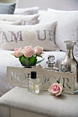 Roses, perfume and silver vase on bedside table