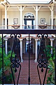 View into elegant hotel courtyard with colonnade from balcony with wrought iron balustrade