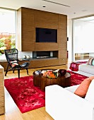 Wohnzimmer mit deckenhoher Schrankwand aus Walnussfurnier mit eingebautem Fernseher & Gaskamin