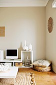 Naturfarben im Wohnzimmer mit traditionellem Flair - Weisser Bodentisch auf Sisalteppich und Bodenkissen in Zimmerecke vor beige getönten Wänden