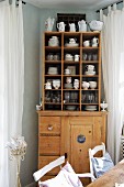 Old crockery in compartments on top of old wooden kitchen dresser