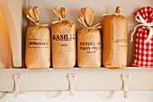 Labelled paper bags of herbs on kitchen shelf