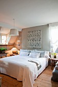 Doppelbett in Schlafzimmer unterm Dach mit romantischer Landhausdeko