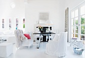 Bright living room - armchairs with white loose covers and rustic table opposite terrace door
