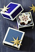 Star-shaped Christmas chocolates in small blue boxes with gold glittery stars