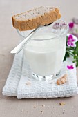 Glass of milk and shortbread with scented geranium oil