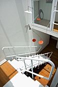 Mobile im Stile Alexander Calders über Wohnraumtreppe aus weiss lackiertem Metall