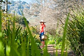 Frau trägt einen Korb im Garten
