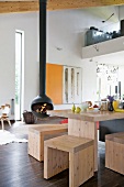 Plain, pale wooden stools and table in open-plan interior with Chimney Anthrax Bubble fireplace by Andrea Crosetta
