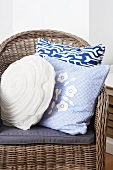Wicker chair with blue and white scatter cushions