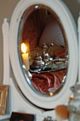 Breakfast tray with antique silver pots on bed reflected in mirror of dressing table