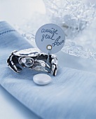 Stylised metal crab with handwritten sign on white linen napkin