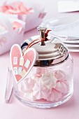 Glass jar with heart-shaped tag filled with miniature meringues
