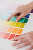 Close up of woman comparing paint swatches