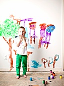 Toddler boy (2-3) painting on wall