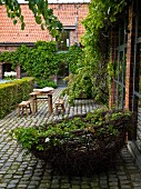 Gepflasterter Innenhof mit dekorativem Nest aus Weidenzweigen