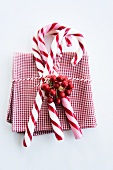 Candy canes and holly berries on napkin