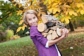 Germany, Leipzig, Boy holding firewood, smiling