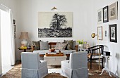 Wohnzimmer in Naturfarben mit antikem Holzsofa und darüber hängendem fotorealistischen Bild