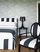 Black and white bedroom with intricately patterned wallpaper