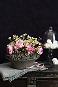 Blumenbouquet mit Rosen in einer romantischen Steinschale